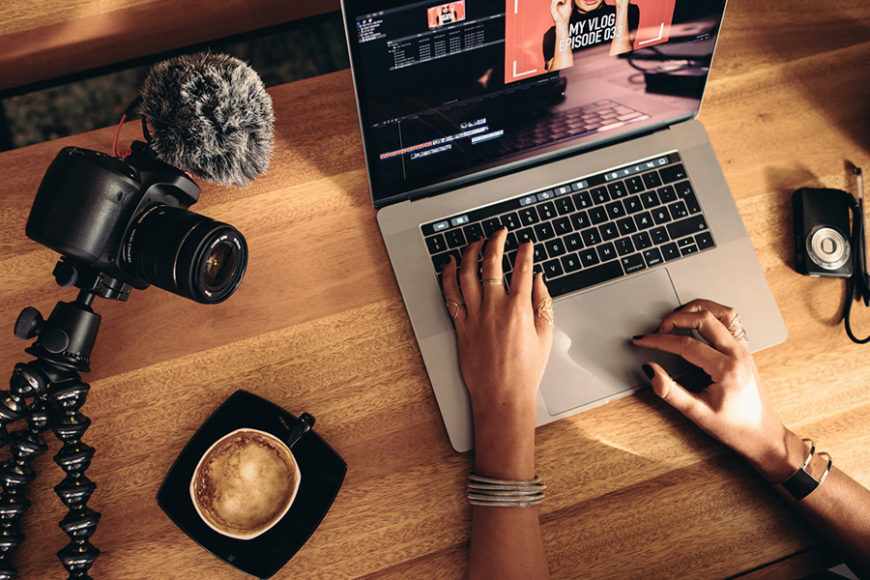 Person editing their vlog with professional camera in shot