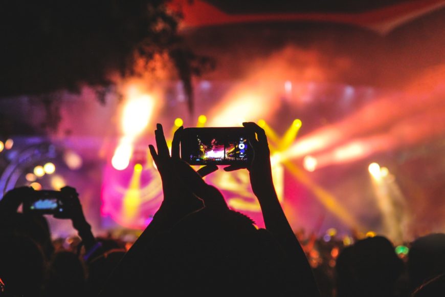 Crowd watches a concert through their phone and is live-streaming it to even greater audiences