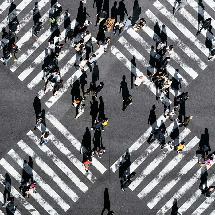 Influencers drawing people across a busy city street different directions