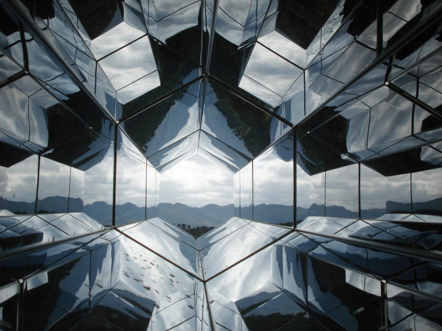 A cool-toned view of mountains in the distance through a horizontal kaleidoscope.