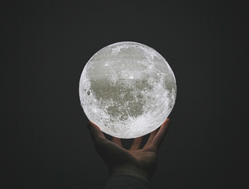 A hand holding a brightly-lit sphere