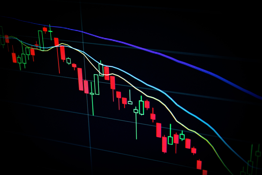 A black background of a graph with blue, green, and red lines showing a downward trend