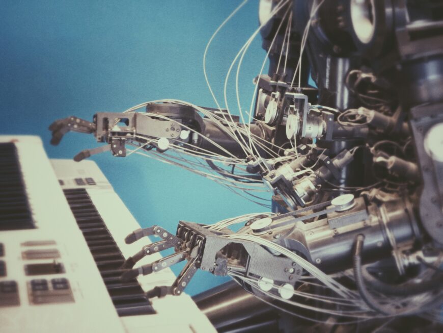 A picture of a robot playing a keyboard against a blue background.