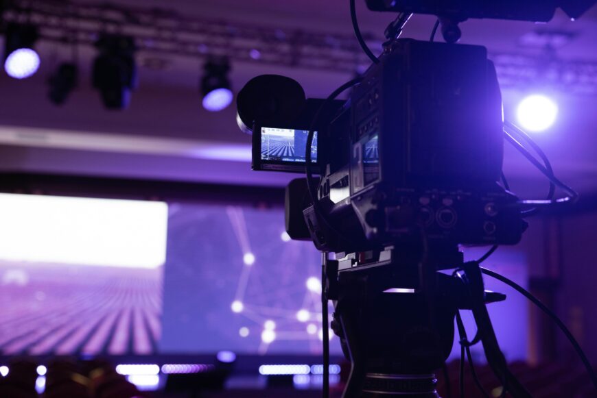 A picture of a video camera with a purple hue.